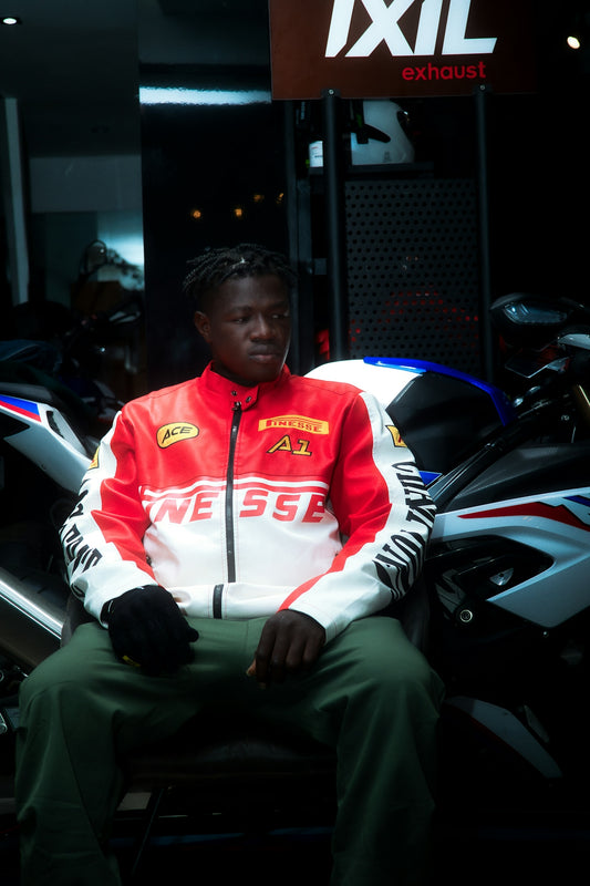 Young man in racing jacket sits on motorcycle